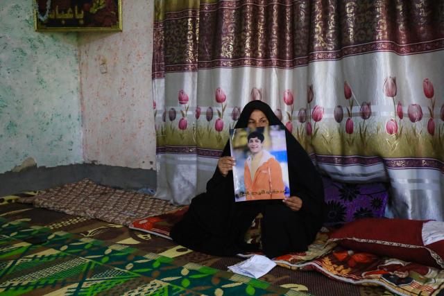 Zeinab Jabbar shows an image of her son, Mohammed Imad, with whom she lost contact after he travelled to Russia to enlist in its armed forces, at her home in Musayab, south of Baghdad, on September 10, 2025.  (Photo by Karrar Jabbar / AFP)