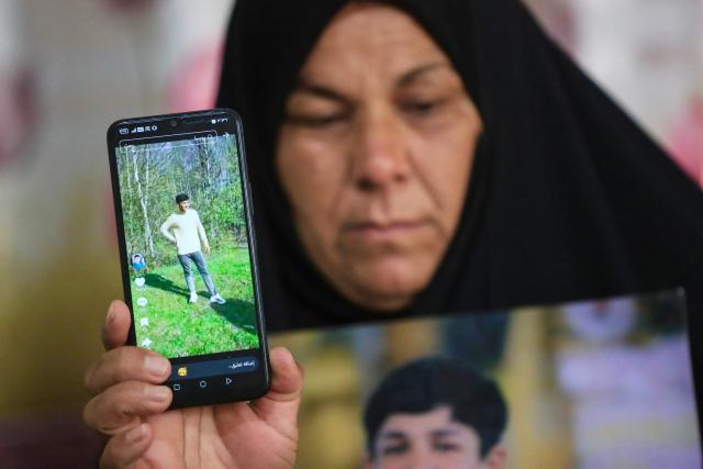 Zeinab Jabbar shows an image of her son, Mohammed Imad, with whom she lost contact after he travelled to Russia to enlist in its armed forces, at her home in Musayab, south of Baghdad, on September 10, 2025.  (Photo by Karrar Jabbar / AFP)