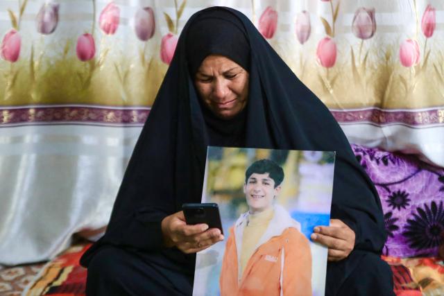 Zeinab Jabbar shows an image of her son, Mohammed Imad, with whom she lost contact after he travelled to Russia to enlist in its armed forces, at her home in Musayab, south of Baghdad, on September 10, 2025.  (Photo by Karrar Jabbar / AFP)