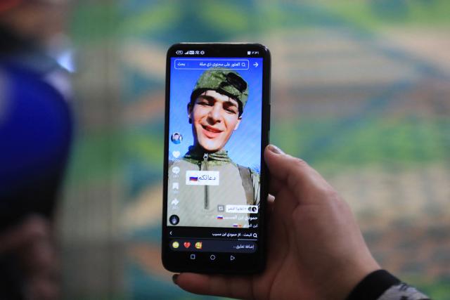 This photograph shows a social media post of Mohammed Imad, a 24-year-old Iraqi whose family lost contact with him after he travelled to Russia to enlist in its armed forces, displayed on a mobile phone at his family home in Musayab, south of Baghdad, on September 10, 2025.  (Photo by Karrar Jabbar / AFP)