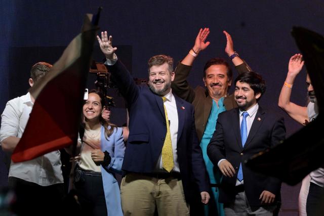 Chile's presidential candidate Johannes Kaiser (C) of the Libertarian National party, waves to supporters next to his wife, Ivette Avaria Vera, during a rally after a national tour, in Santiago on November 4, 2025. Chile will hold the presidential election on November 16, 2025. (Photo by RODRIGO ARANGUA / AFP)