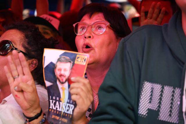 A supporter of Chile's presidential candidate Johannes Kaiser, of the Libertarian National party, gestures as she waits for his arrival to a rally after a national tour, in Santiago on November 4, 2025. Chile will hold the presidential election on November 16, 2025. (Photo by RODRIGO ARANGUA / AFP)