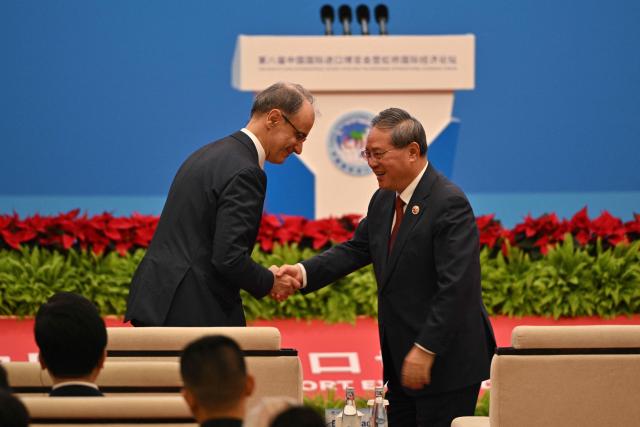 Serbian Prime Minister Djuro Macut (L) shakes hands with China's Premier Li Qiang (R) during the opening ceremony of the 8th China International Import Expo (CIIE) and the Hongqiao International Economic Forum in Shanghai on November 5, 2025. (Photo by Hector RETAMAL / AFP)