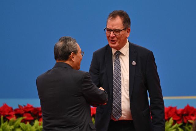 Gerd Müller (R), Director General of the United Nations Industrial Development Organization (UNIDO) shakes hands with China's Premier Li Qiang (L) the opening ceremony of the 8th China International Import Expo (CIIE) and the Hongqiao International Economic Forum in Shanghai on November 5, 2025. (Photo by Hector RETAMAL / AFP)