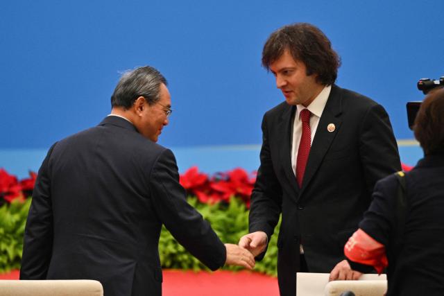 Georgian Prime Minister Irakli Kobakhidze (R) shakes hands with China's Premier Li Qiang (L) during the opening ceremony of the 8th China International Import Expo (CIIE) and the Hongqiao International Economic Forum in Shanghai on November 5, 2025. (Photo by Hector RETAMAL / AFP)