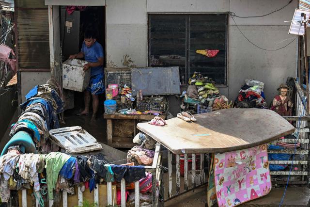 TOPSHOT - Residents clean up their damaged houses in the aftermath of Typhoon Kalmaegi in Talisay, in the province of Cebu on November 5, 2025. (Photo by Jam STA ROSA / AFP)