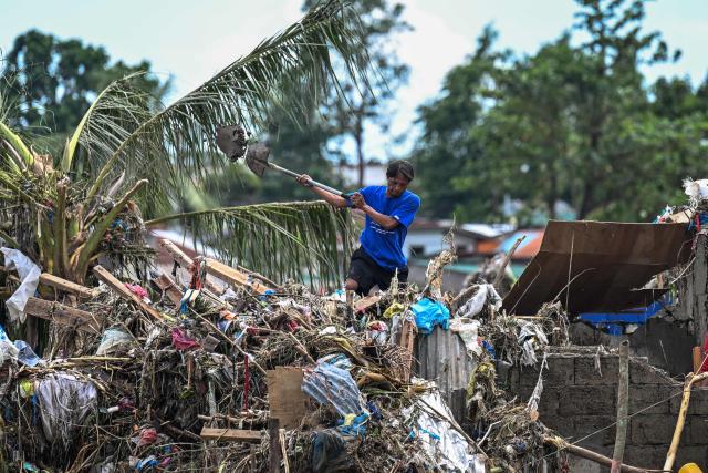 Residents clean up their damaged houses in the aftermath of Typhoon Kalmaegi in Talisay, in the province of Cebu on November 5, 2025. (Photo by Jam STA ROSA / AFP)