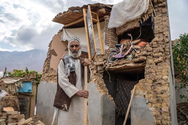 TOPSHOT - An Afghan man stands in front of his damaged house, in the aftermath of an earthquake at a village in the Khulm district of Samangan province on November 4, 2025. An earthquake of 6.3-magnitude in northern Afghanistan has killed at least 27 people and injured nearly 1,000, the health ministry said on November 4, announcing the end of rescue operations. (Photo by AFP)