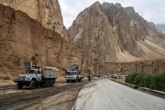 Trucks drive along a highway past a mountain range, in the aftermath of an earthquake at Tang-e Tashkurgan in Khulm district, Samangan province on November 4, 2025. An earthquake of 6.3-magnitude in northern Afghanistan has killed at least 27 people and injured nearly 1,000, the health ministry said on November 4, announcing the end of rescue operations. (Photo by AFP)