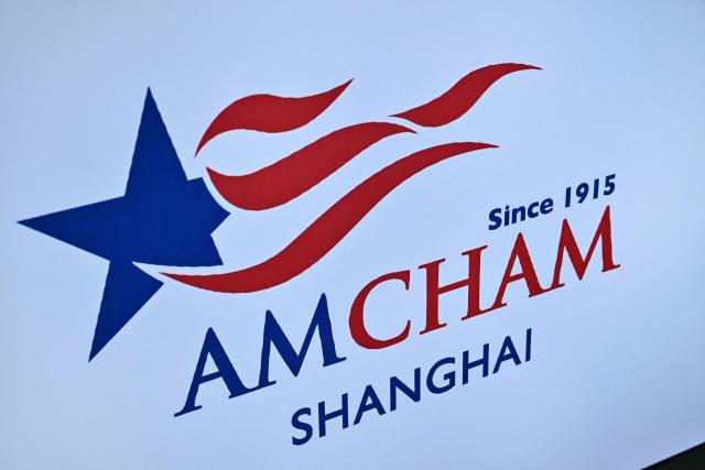 A logo of the American Chamber of Commerce (AMCHAM) is seen during the 8th China International Import Expo (CIIE) in Shanghai on November 5, 2025. China said on November 5, it would extend a suspension of additional tariffs on US goods for one year, making official an agreement reached in talks between presidents Xi Jinping and Donald Trump last week. (Photo by Hector RETAMAL / AFP)