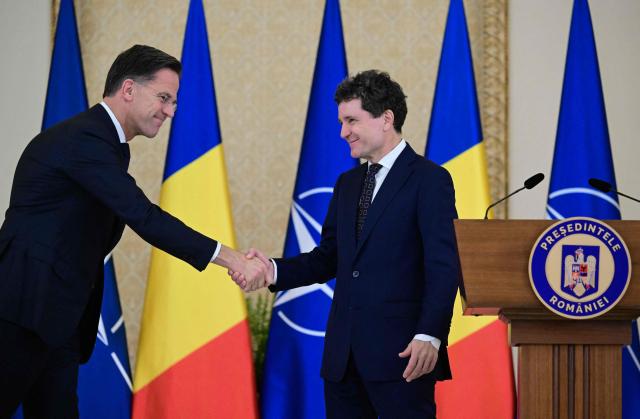 NATO Secretary General Mark Rutte and Romanian President Nicusor Dan (R) shake hands following a press conference at the presidential Cotroceni Palace in Bucharest, Romania, on November 5, 2025. (Photo by Daniel MIHAILESCU / AFP)