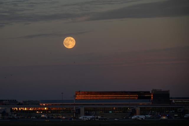This picture taken on November 5, 2025 shows the supermoon, also known as the Beaver Moon, rising above the Chopin Airport in Warsaw, Poland. (Photo by Sergei GAPON / AFP)
