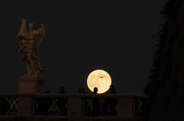 A supermoon, also called Beaver Moon, rises behind Sant'Angelo bridge in Rome on November 5, 2025. (Photo by Tiziana FABI / AFP)