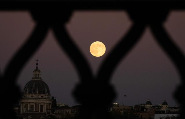 A supermoon, also called Beaver Moon, rises behind Sant'Angelo bridge in Rome on November 5, 2025. (Photo by Tiziana FABI / AFP)