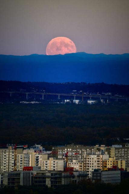 The full moon, known as Beaver Moon, rises over the city of Lyon, on November 5,2025. (Photo by OLIVIER CHASSIGNOLE / AFP)