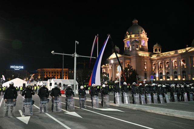 Serbian riot police stand in between anti-corruption protesters and government supporters outside Serbia's parliament building in Belgrade, on November 5, 2025, as a year of dissent against the right-wing government continues to roil the Balkan nation. The competing protests followed a weekend rally in Novi Sad, where tens of thousands of anti-government protesters gathered to mark the first anniversary of the fatal railway station roof collapse that sparked the movement. (Photo by Andrej ISAKOVIC / AFP)