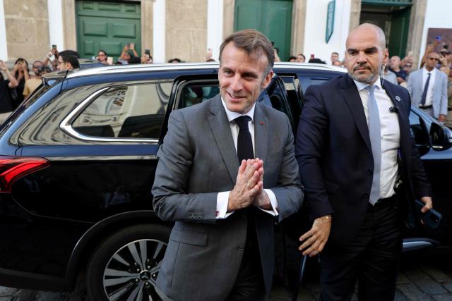 France's President Emmanuel Macron gestures to locals and tourists upon his arrival at the Pelourinho historic district, in Salvador, Bahia State, Brazil on November 5, 2025. (Photo by Ludovic MARIN / AFP)