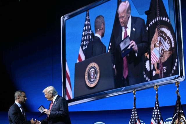 US President Donald Trump accepts a "key to the city" from Miami Mayor Francis Suarez at the American Business Forum at the Kaseya Center in Miami on November 5, 2025. (Photo by Brendan SMIALOWSKI / AFP)