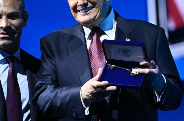 US President Donald Trump accepts a "key to the city" from Miami Mayor Francis Suarez at the American Business Forum at the Kaseya Center in Miami on November 5, 2025. (Photo by Brendan SMIALOWSKI / AFP)