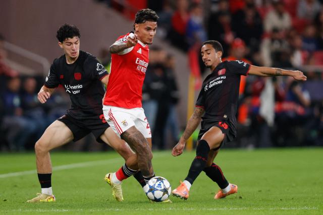 SL Benfica's Colombian midfielder #20 Richard Rios (C) is challenged by Bayer Leverkusen's Algerian midfielder #30 Ibrahim Maza (L) and Bayer Leverkusen's Brazilian defender #13 Arthur during the UEFA Champions League league phase day 4 football match between SL Benfica and Bayer Leverkusen at Estadio da Luz in Lisbon on November 5, 2025. (Photo by FILIPE AMORIM / AFP)