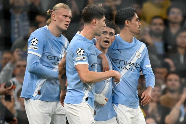Manchester City's English midfielder #47 Phil Foden (2R) is mobbed by teammates after scoring the team's first goal during the UEFA Champions League football match between Manchester City and Borussia Dortmund at the Etihad Stadium in Manchester, north west England, on November 5, 2025. (Photo by Oli SCARFF / AFP)