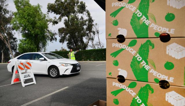 A driver is directed to receive free food from the Los Angeles Regional Food Bank on November 5, 2025, in City of Industry, California. The US government shutdown became the longest ever on November 5, 2025, topping the 35-day record set during Donald Trump's first term, as his administration warned of holiday air travel chaos and threatened Americans' benefits in a bid to force a resolution. (Photo by Frederic J. BROWN / AFP)