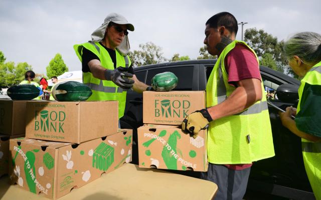 Frozen chicken sit on boxes as people arrive in vehicles to receive free food from the Los Angeles Regional Food Bank on November 5, 2025, in City of Industry, California. The US government shutdown became the longest ever on November 5, 2025, topping the 35-day record set during Donald Trump's first term, as his administration warned of holiday air travel chaos and threatened Americans' benefits in a bid to force a resolution. (Photo by Frederic J. BROWN / AFP)