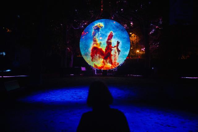 Visitors look at a light structure during a press preview of the exhibition entitled "Lights of Nature" at the Jardin des Plantes in Paris, on November 5, 2025. (Photo by Dimitar DILKOFF / AFP)