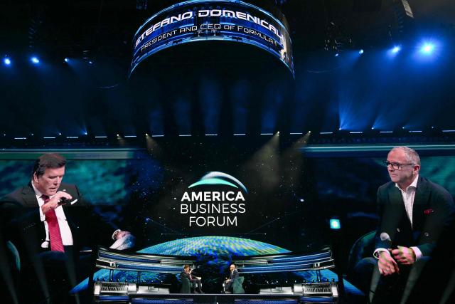 Stefano Domenicali (R), CEO of Formula 1, listens to a question from US journalist Bret Baier during the American Business Forum at the Kaseya Center in Miami on November 5, 2025. (Photo by CHANDAN KHANNA / AFP)