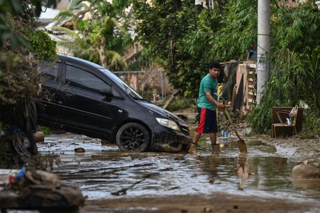 A resident cleans up his house in the aftermath of Typhoon Kalmaegi in Liloan, in the province of Cebu on November 6, 2025. The death toll from Typhoon Kalmaegi in the central Philippines climbed past 100, as the devastating impact on Cebu province became clearer after the worst flooding in recent memory. (Photo by Jam STA ROSA / AFP)