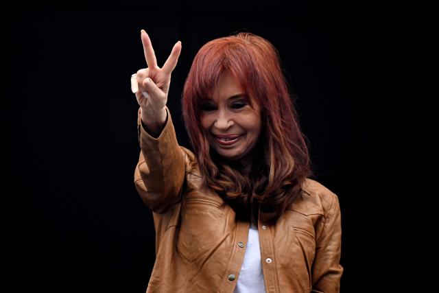 (FILES) Argentina's former President (2007-2015) and vice-president (2019-2023) Cristina Fernandez de Kirchner waves at supporters from the balcony of her residence where she is serving house arrest in Buenos Aires on September 20, 2025, on the 100th day of her arrest. Argentine ex-president Cristina Kirchner, who is serving a six-year fraud sentence under house arrest, goes on trial on November 6, 2025, in a separate case for allegedly taking millions of dollars in bribes. The center-left Kirchner, a dominant and polarizing figure in Argentine politics for over two decades, served two terms from 2007 to 2015. (Photo by Luis ROBAYO / AFP)