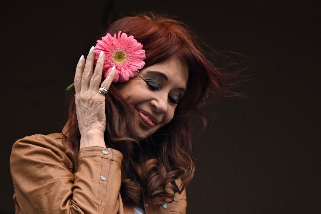 (FILES) Argentina's former President (2007-2015) and vice-president (2019-2023) Cristina Fernandez de Kirchner gestures as she greets supporters from the balcony of her residence where she is serving house arrest in Buenos Aires on September 20, 2025, on the 100th day of her arrest. Argentine ex-president Cristina Kirchner, who is serving a six-year fraud sentence under house arrest, goes on trial on November 6, 2025, in a separate case for allegedly taking millions of dollars in bribes. The center-left Kirchner, a dominant and polarizing figure in Argentine politics for over two decades, served two terms from 2007 to 2015. (Photo by Luis ROBAYO / AFP)