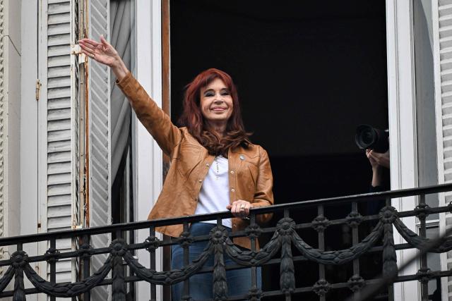 (FILES) Argentina's former President (2007-2015) and vice-president (2019-2023) Cristina Fernandez de Kirchner waves at supporters from the balcony of her residence where she is serving house arrest in Buenos Aires on September 20, 2025, on the 100th day of her arrest. Argentine ex-president Cristina Kirchner, who is serving a six-year fraud sentence under house arrest, goes on trial on November 6, 2025, in a separate case for allegedly taking millions of dollars in bribes. The center-left Kirchner, a dominant and polarizing figure in Argentine politics for over two decades, served two terms from 2007 to 2015. (Photo by Luis ROBAYO / AFP)