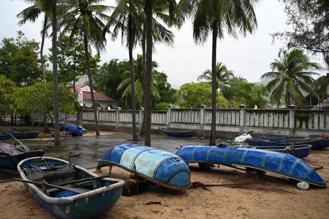 Boats are temporarily overturned in Gia Lai province, central Vietnam on November 6, 2025, in anticipation of the arrival of typhoon Kalmaegi. The typhoon is forecast to make landfall in central Vietnam late on November 6, bringing waves as high as eight metres (26 feet) and powerful storm surges, according to the national weather bureau. (Photo by NHAC NGUYEN / AFP)