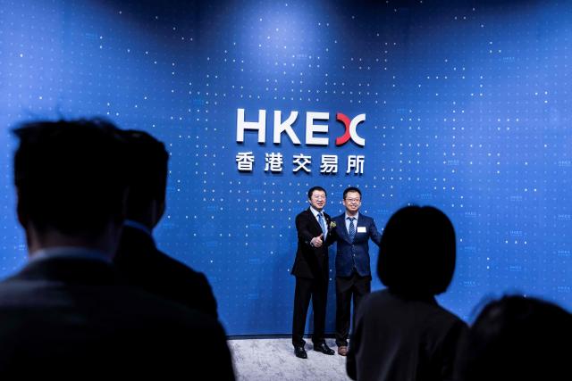 CEO of WeRide Tony Han (C) attends the companies initial public offering (IPO) launch at the Hong Kong Stock Exchange on November 6, 2025. Shares in Chinese self-driving start-ups Pony.AI and WeRide falls on their first listing day in Hong Kong, as experts warns China has not fully ready to deploy a mass rollout of robotaxis due to regulatory changes. (Photo by ISAAC LAWRENCE / AFP)