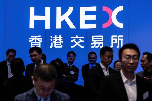 People attend the initial public offering (IPO) launch of Pony.AI and WeRide at the Hong Kong Stock Exchange on November 6, 2025. Shares in Chinese self-driving start-ups Pony.AI and WeRide falls on their first listing day in Hong Kong, as experts warns China has not fully ready to deploy a mass rollout of robotaxis due to regulatory changes. (Photo by ISAAC LAWRENCE / AFP)