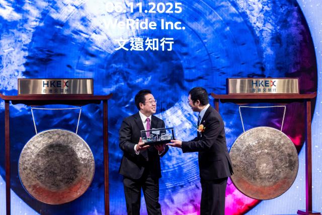 CEO of WeRide Tony Han (R) attends the companies initial public offering (IPO)) launch at the Hong Kong Stock Exchange on November 6, 2025. Shares in Chinese self-driving start-ups Pony.AI and WeRide falls on their first listing day in Hong Kong, as experts warns China has not fully ready to deploy a mass rollout of robotaxis due to regulatory changes. (Photo by ISAAC LAWRENCE / AFP)