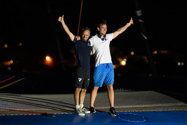 "SVR-LAZARTIGUE" ULTIM class multihull French skippers Franck Cammas (L) and Tom Laperche, celebrate while crossing the finish line to win the 17th edition of the Transat Cafe L'Or, off the shores of Fort-de-France, in the French overseas island of Martinique on November 5, 2025. Four open classes will take part in the race: IMOCA, Ocean Fifty, ULTIM and Class40. The Transat Cafe L'Or is a duo sailing race from Le Havre to Fort-de-France, in the French Caribbean island of Martinique. (Photo by Loic VENANCE / AFP)