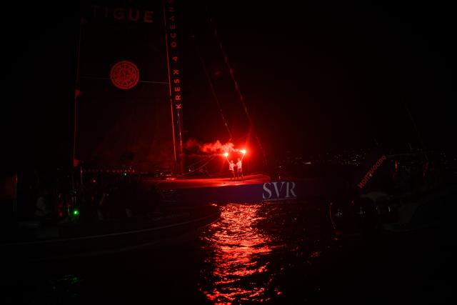"SVR-LAZARTIGUE" ULTIM class multihull French skippers Franck Cammas (L) and Tom Laperche, celebrate with flares after crossing the finish line to win the 17th edition of the Transat Cafe L'Or, off the shores of Fort-de-France, in the French overseas island of Martinique on November 5, 2025. Four open classes will take part in the race: IMOCA, Ocean Fifty, ULTIM and Class40. The Transat Cafe L'Or is a duo sailing race from Le Havre to Fort-de-France, in the French Caribbean island of Martinique. (Photo by Loic VENANCE / AFP)