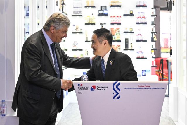 French Deputy Minister for Foreign Trade Nicolas Forissier (L) and deputy director-general of the CIIE Bureau Wu Zhengping shake hands during the inauguration of the pavillion of France during the 8th International Import Expo (CIIE) in Shanghai on November 6, 2025. (Photo by Hector RETAMAL / AFP)