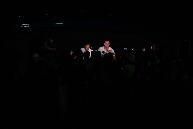 People celebrate on a boat as "SVR-LAZARTIGUE" ULTIM class multihull French skippers Franck Cammas (L) and Tom Laperche, answer journalists after winning the 17th edition of the Transat Cafe L'Or, off the shores of Fort-de-France, in the French overseas island of Martinique on November 5, 2025. Four open classes will take part in the race: IMOCA, Ocean Fifty, ULTIM and Class40. The Transat Cafe L'Or is a duo sailing race from Le Havre to Fort-de-France, in the French Caribbean island of Martinique. (Photo by Loic VENANCE / AFP)