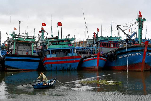 A man pulls a rope from a fishing boat as people prepare vessels for the impact of Typhoon Kalmaegi at Quy Nhon fishing port in Gia Lai province in central Vietnam on November 6, 2025. The typhoon is forecast to make landfall in central Vietnam late on November 6, bringing waves as high as eight metres (26 feet) and powerful storm surges, according to the national weather bureau. (Photo by Nhac NGUYEN / AFP)
