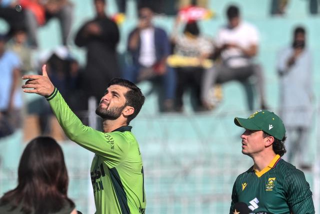 Pakistan's captain Shaheen Shah Afridi (L) tosses the coin as his South African counterpart Matthew Breetzke watches before the start of the second one-day international (ODI) cricket match between Pakistan and South Africa at the Iqbal Stadium in Faisalabad on November 6, 2025. (Photo by Aamir QURESHI / AFP)