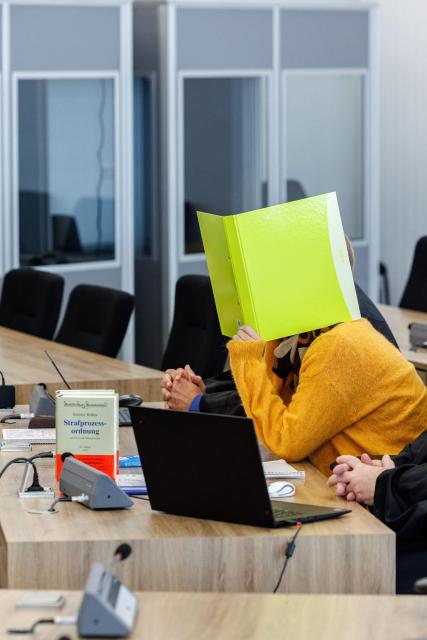 Defendant Susann E. hides behind a folder as she sits in the courtroom at the start of her trial as suspected supporter of the far-right extremist cell National Socialist Underground (NSU), on November 6, 2025 at the Higher Regional Court of Dresden. The National Socialist Underground (NSU) was a neo-Nazi cell behind a string of racist murders of mostly Turkish and Greek-born immigrants across Germany between 2000 and 2007. (Photo by JENS SCHLUETER / POOL / AFP)
