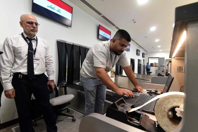 An airport employee looks at a screen at the check-in counter during the officially opening of Mosul Airport for domestic flights, in Mosul, northern Iraq on November 6, 2025. Mosul Airport witnessed the landing of the first official passenger plane, Iraqi Airways, coming from Baghdad and returning with 66 passengers bound for the Iraqi capital. (Photo by Zaid AL-OBEIDI / AFP)