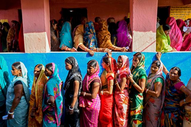 TOPSHOT - Women voters stand in queues to cast their ballots at a polling station during the first phase of voting for assembly elections on November 6, 2025, at the Raghopur constituency in the Vaishali district of the Indian state of Bihar. (Photo by Sachin KUMAR / AFP)
