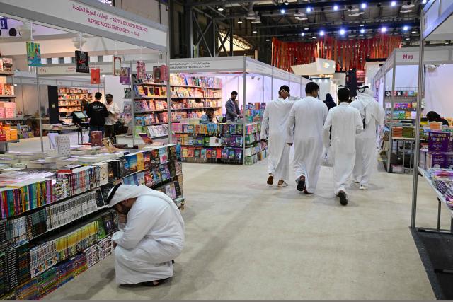 People attend the Sharjah International Book Fair in the Gulf emirate of Sharjah, on November 6, 2025. (Photo by Giuseppe CACACE / AFP)