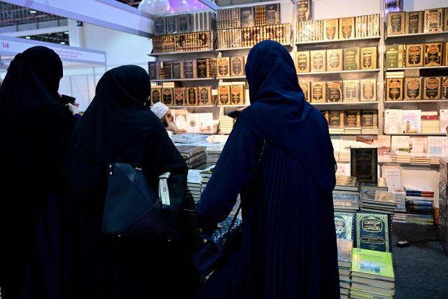 People attend the Sharjah International Book Fair in the Gulf emirate of Sharjah, on November 6, 2025. (Photo by Giuseppe CACACE / AFP)