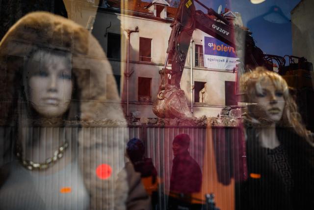 TOPSHOT - This photograph taken on November 6, 2025, shows a reflection in a boutique window of the construction site at 48, Rue de la République in Saint-Denis, North of Paris, the building where the RAID raid took place after the attacks of November 13, 2015.  (Photo by Dimitar DILKOFF / AFP)