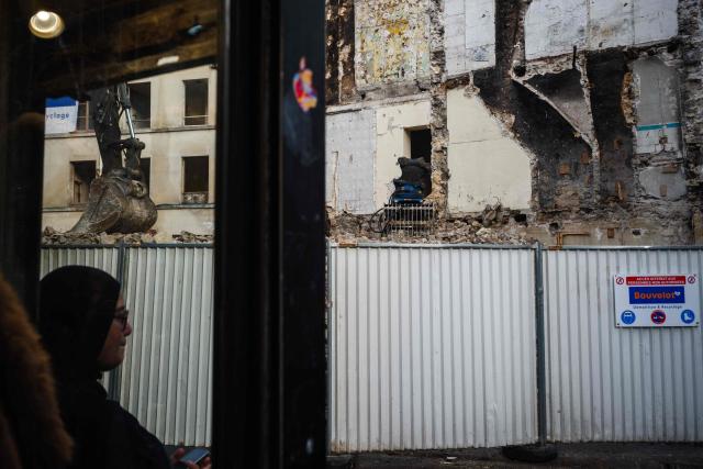 A woman stands next the construction site at 48, Rue de la République in Saint-Denis, North of Paris on November 6, 2025, where the RAID raid took place after the attacks of November 13, 2015. (Photo by Dimitar DILKOFF / AFP)